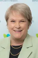 women smiling in a green jacket and gold necklace
